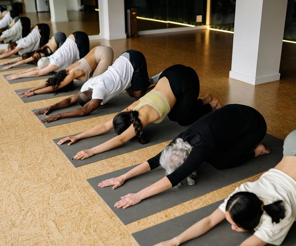 A diverse group of people smiling and relaxing after a yoga session.